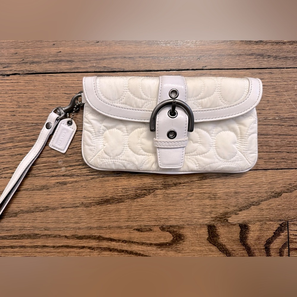 Gently used white Coach wristlet with buckle closure